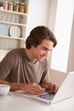 Young man using laptop. Photo : Rob Lewine