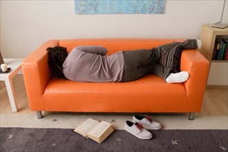 Man sleeping on sofa. Photo : Rob Lewine