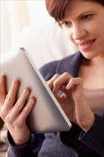 Smiling woman using digital tablet. Photo : Rob Lewine