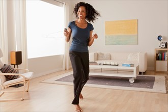 Mid adult woman dancing at home. Photo : Rob Lewine