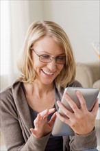 Smiling mid adult woman using digital tablet. Photo : Rob Lewine