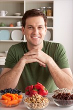 Portrait of mid adult man with healthy fruits. Photo : Rob Lewine