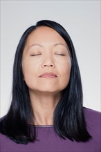 Studio portrait of mature woman with eyes closed. Photo : Rob Lewine