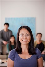 Portrait of mature woman with family in background. Photo : Rob Lewine