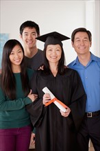 Portrait of mature woman in graduation gown with family. Photo : Rob Lewine