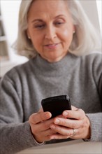 Portrait of smiling senior woman using mobile. Photo : Rob Lewine