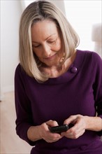 Portrait of smiling senior woman with mobile phone. Photo : Rob Lewine