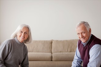 Portrait of senior couple sitting on sofa. Photo : Rob Lewine