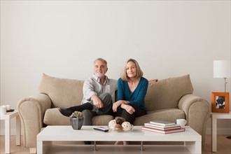 Happy senior couple sitting on sofa. Photo : Rob Lewine