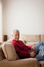 Portrait of senior man sitting in armchair. Photo : Rob Lewine
