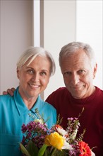 Portrait of senior couple with flowers. Photo : Rob Lewine