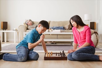 Siblings playing chess game. Photo : Rob Lewine