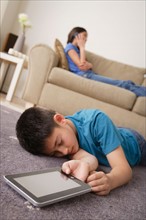 Boy sleeping on floor with iPad in hand. Photo : Rob Lewine