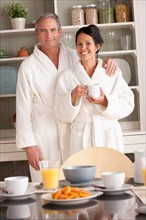 Couple in bathrobes with coffee cups. Photo : Rob Lewine