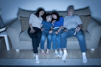 Family sitting on sofa sleeping. Photo : Rob Lewine