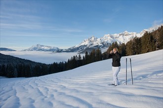 Austria, Maria Alm. Young woman hiking in winter scenery. Photo : Mark de Leeuw