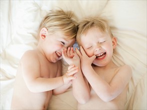 Two toddler boys (2-3) messing about in bed. Photo : Jessica Peterson