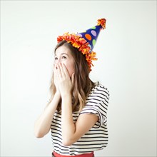 Studio shot of young woman wearing party hat. Photo : Jessica Peterson