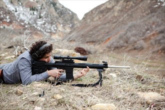 USA, Utah, Spanish Fork. Man lying on front with weapon. Photo : Jessica Peterson