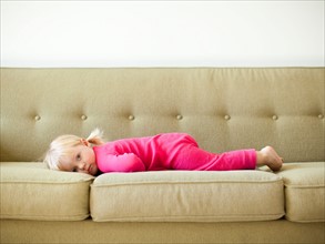 Portrait of baby girl (18-23 months) resting on sofa. Photo : Jessica Peterson