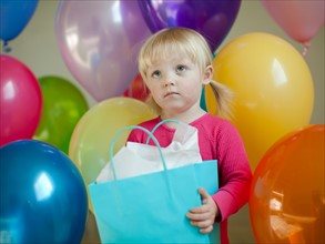 Portrait of baby girl (18-23 months) wit colorful balloons. Photo : Jessica Peterson
