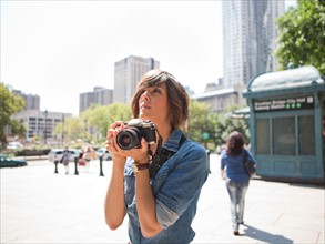 USA, New York, New  York City. Young woman holding photo camera. Photo : Jessica Peterson