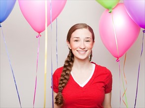 Studio Shot of young woman holding balloons. Photo : Jessica Peterson