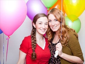Studio Shot of young women holding balloons. Photo : Jessica Peterson