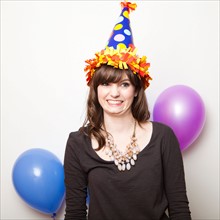 Studio Shot of young woman dressed in party hat. Photo : Jessica Peterson