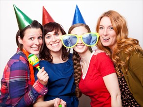 Studio Shot of young women dressed in party hat. Photo : Jessica Peterson