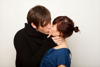 Studio Shot of young couple kissing . Photo : Jessica Peterson