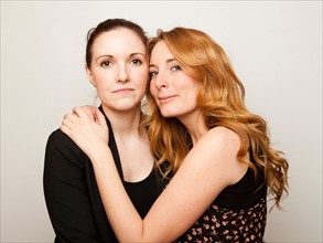 Studio Shot portrait of young women embracing. Photo : Jessica Peterson