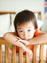 Portrait of girl leaning on bed frame (2-3). Photo : Jessica Peterson