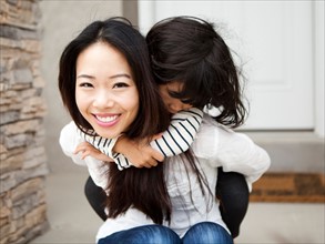 Smiling woman embracing by her daughter (4-5). Photo : Jessica Peterson