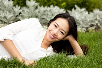 View of smiling woman lying on lawn. Photo : Jessica Peterson