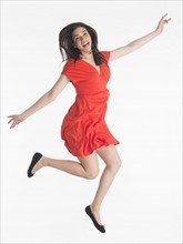 Studio portrait of young woman jumping.
