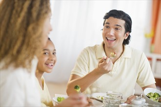 Parents with daughter (12-13) eating dinner.