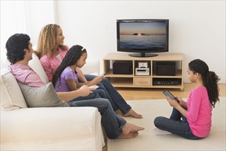 Parents with daughters (10-13) watching tv.