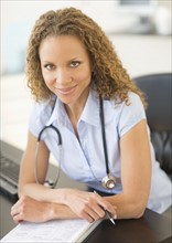 Portrait of female doctor at desk.