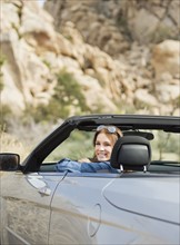 USA, California, Joshua Tree National Park, Young woman driving convertible.