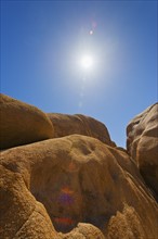 USA, California, Joshua Tree National Park, Desert rocks with solar flare.