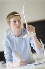 Student (16-17) examining wind turbine.