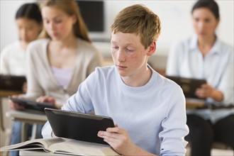 Students (14-19) using digital tablets at school.
