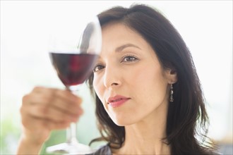 Woman tasting red wine.