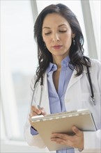 Female doctor holding medical document.