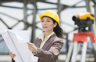 Architect reading blueprint in construction site.