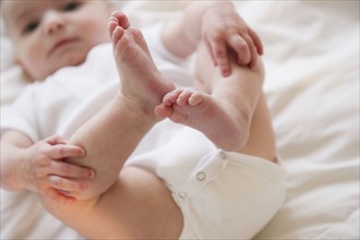 Baby boy (2-5) touching legs. 
Photo : Jamie Grill