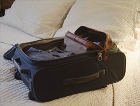 Suitcase on bed. 
Photo : Jamie Grill
