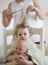 Mother cutting daughter's (2-3) hair. 
Photo : Jamie Grill