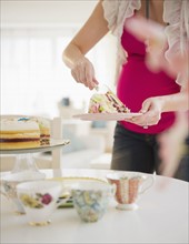Pregnant woman serving cake. 
Photo : Jamie Grill